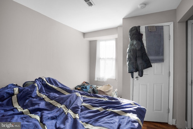 bedroom with visible vents and wood finished floors