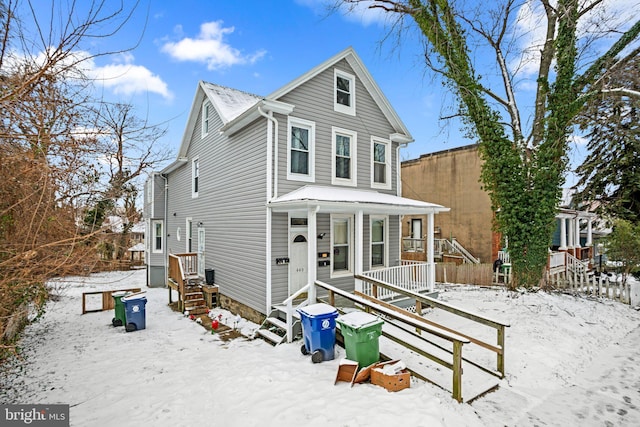 traditional-style home featuring a porch and fence