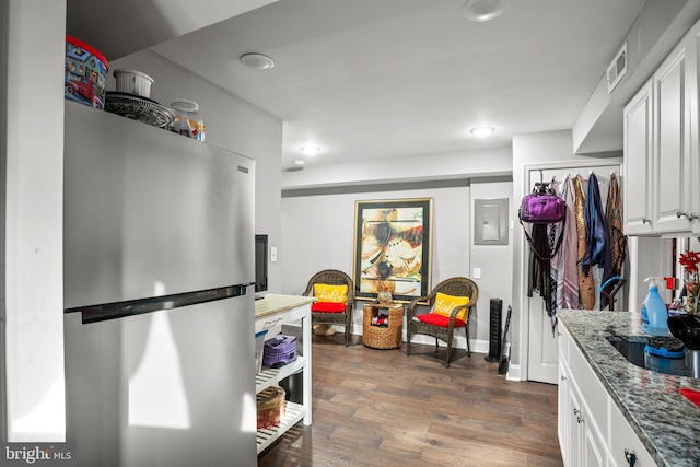 kitchen featuring visible vents, freestanding refrigerator, dark wood-style floors, stone countertops, and white cabinetry