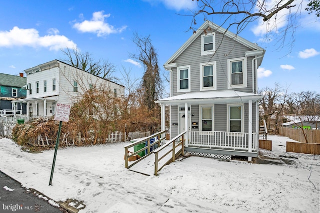 view of front facade featuring a porch and fence