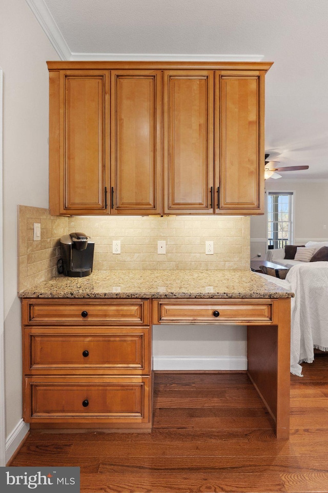 kitchen with backsplash, light stone countertops, and dark wood-type flooring