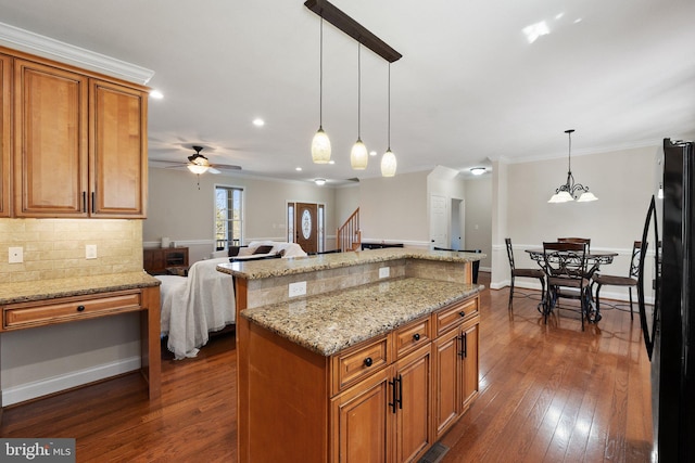 kitchen featuring tasteful backsplash, crown molding, dark wood-type flooring, open floor plan, and freestanding refrigerator