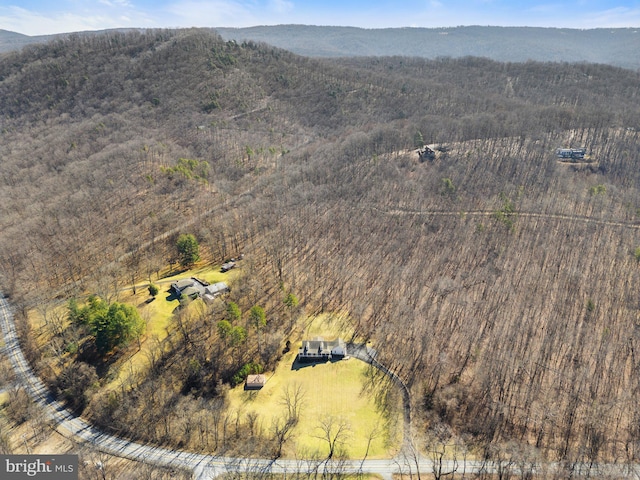 birds eye view of property featuring a wooded view and a mountain view