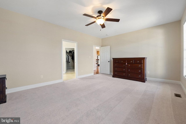 unfurnished bedroom with visible vents, carpet floors, baseboards, and a walk in closet