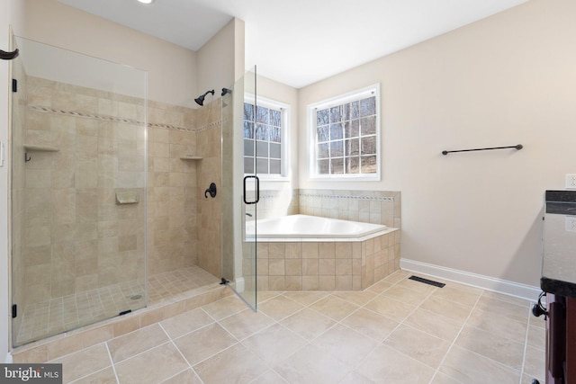 bathroom with tile patterned flooring, baseboards, a stall shower, a bath, and vanity