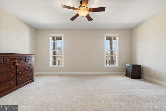 bedroom with multiple windows, baseboards, and light carpet