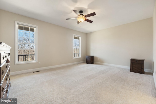 unfurnished bedroom with light carpet, visible vents, ceiling fan, and baseboards