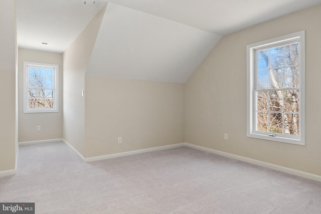 additional living space featuring carpet flooring, a healthy amount of sunlight, and baseboards