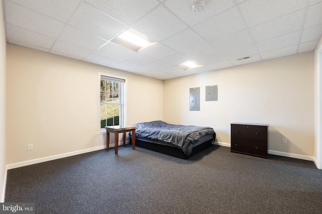 carpeted bedroom featuring electric panel, visible vents, baseboards, and a drop ceiling