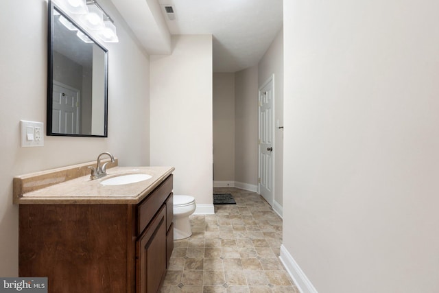 bathroom with visible vents, toilet, vanity, and baseboards