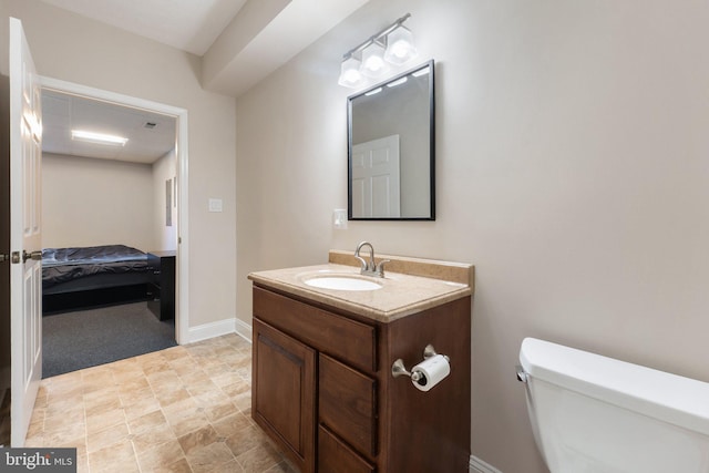 bathroom featuring toilet, vanity, and baseboards