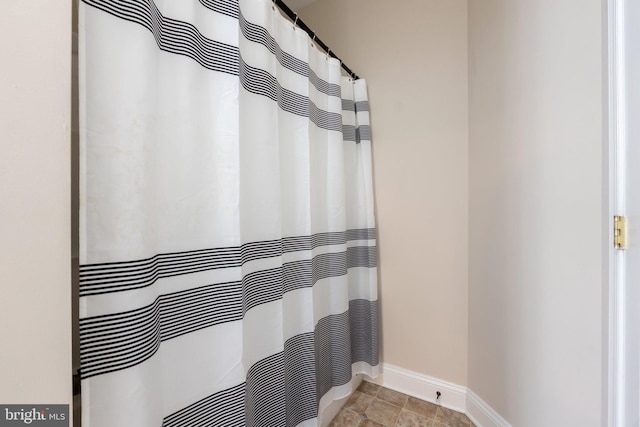 bathroom featuring a shower with curtain and baseboards