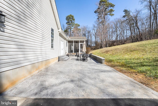 view of patio / terrace featuring entry steps and a sunroom