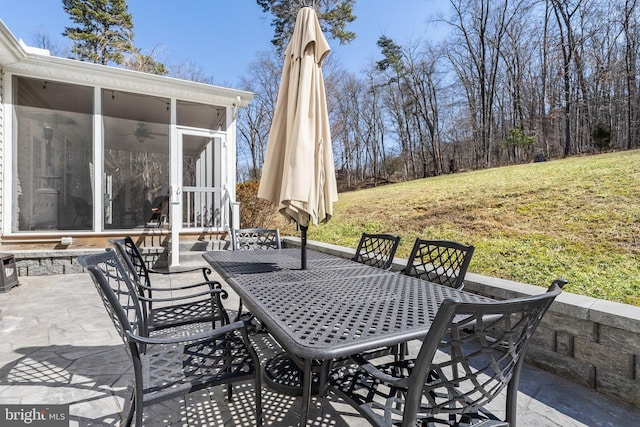 view of patio / terrace with outdoor dining space and a sunroom