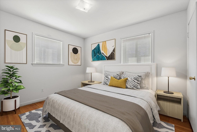 bedroom with baseboards and wood finished floors