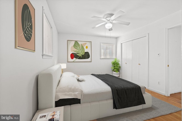 bedroom featuring a closet, baseboards, ceiling fan, and wood finished floors