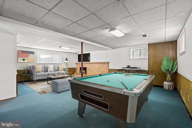 rec room with visible vents, a paneled ceiling, wood walls, and carpet flooring