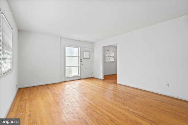 spare room featuring light wood-type flooring and baseboards