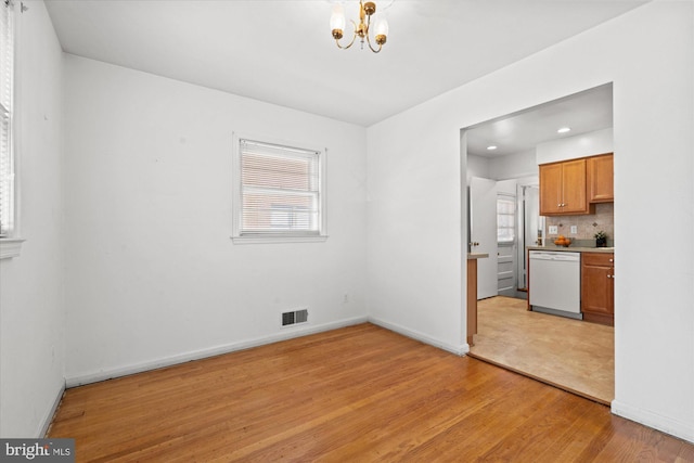 unfurnished dining area featuring visible vents, baseboards, an inviting chandelier, recessed lighting, and light wood-type flooring