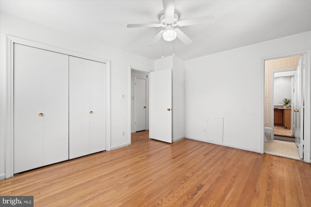 unfurnished bedroom featuring a ceiling fan, wood finished floors, connected bathroom, a closet, and baseboards