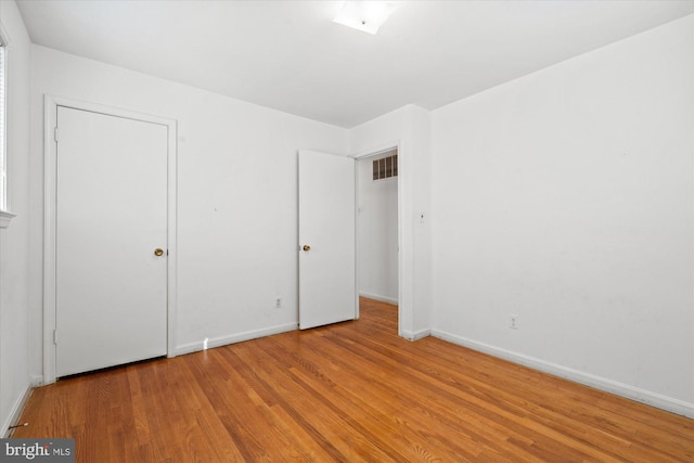 unfurnished bedroom featuring visible vents, baseboards, and light wood-style flooring