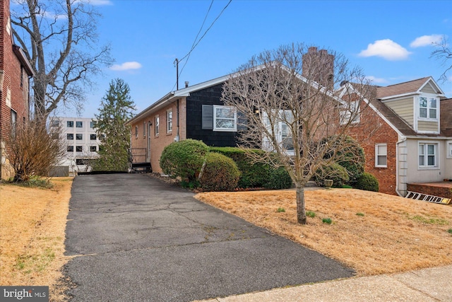 view of front of property featuring brick siding and a chimney