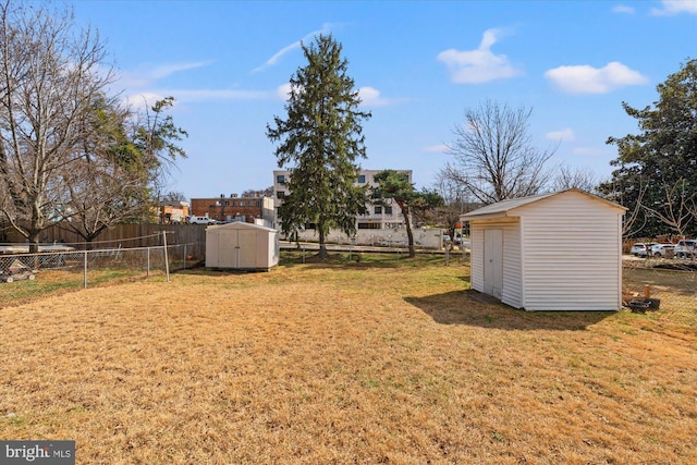 view of yard featuring an outbuilding, a storage shed, and a fenced backyard