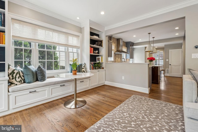 sitting room with crown molding, healthy amount of natural light, wood finished floors, recessed lighting, and baseboards