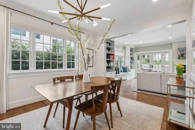 dining room with a chandelier, ornamental molding, wood finished floors, recessed lighting, and baseboards