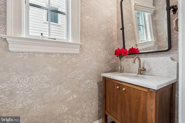 bathroom featuring wallpapered walls and vanity