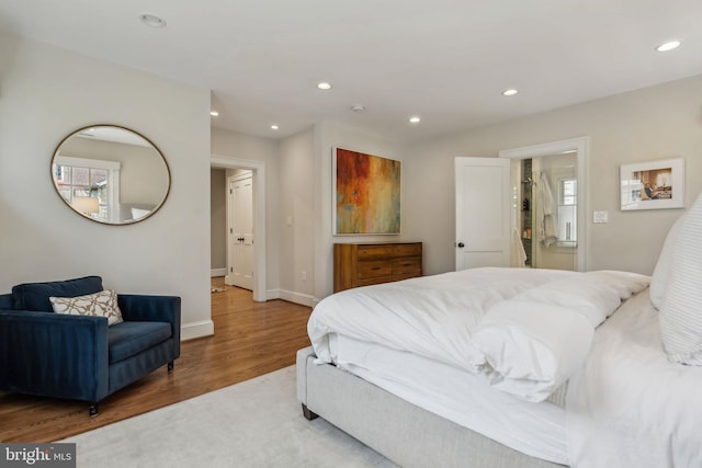 bedroom with wood finished floors, recessed lighting, and baseboards