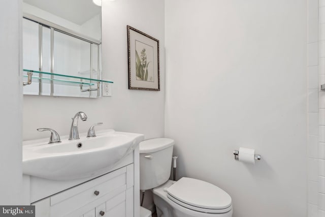 bathroom with toilet, vanity, and a shower