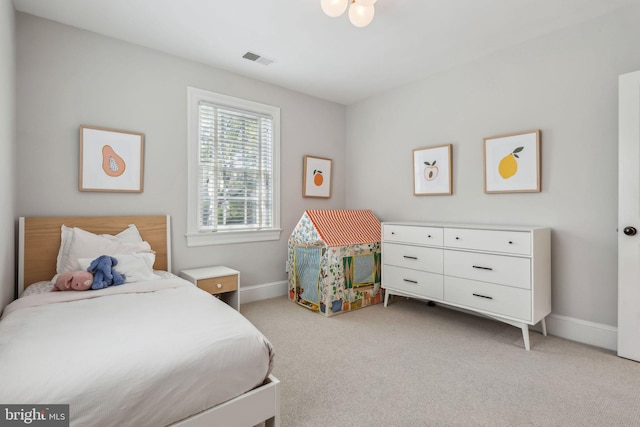 bedroom featuring light carpet and baseboards