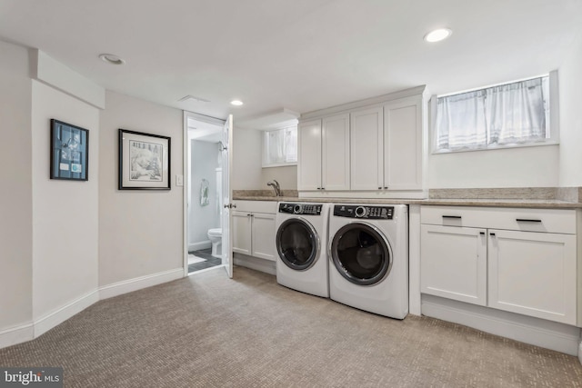laundry room with washing machine and clothes dryer, recessed lighting, light carpet, cabinet space, and baseboards