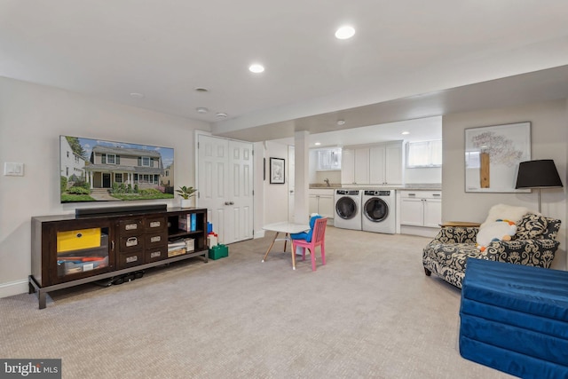 recreation room featuring light carpet, independent washer and dryer, a sink, recessed lighting, and baseboards