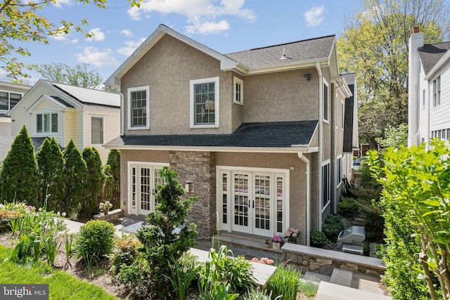 rear view of house with french doors and stucco siding