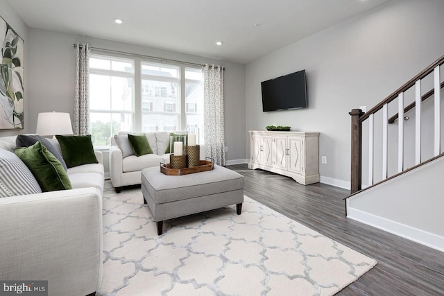 living room with recessed lighting, baseboards, dark wood-type flooring, and stairs