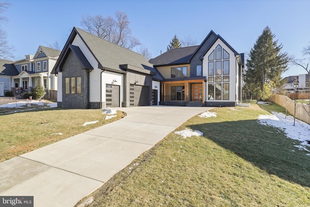 modern inspired farmhouse featuring a front yard, concrete driveway, a garage, and fence