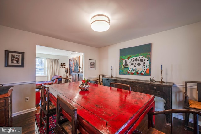 dining space with baseboards and wood finished floors