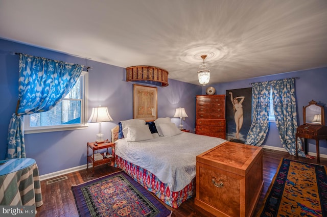 bedroom featuring visible vents, baseboards, and hardwood / wood-style flooring