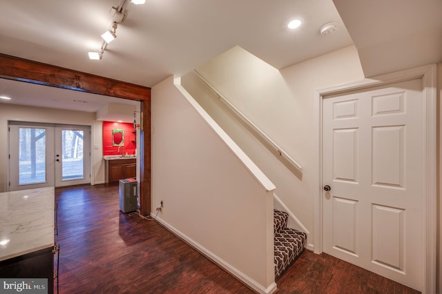 corridor featuring stairway, baseboards, dark wood finished floors, and french doors