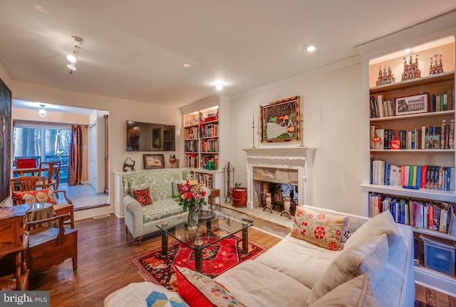 living room with a premium fireplace, wood finished floors, and ornamental molding