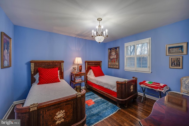 bedroom with an inviting chandelier, wood finished floors, and baseboards