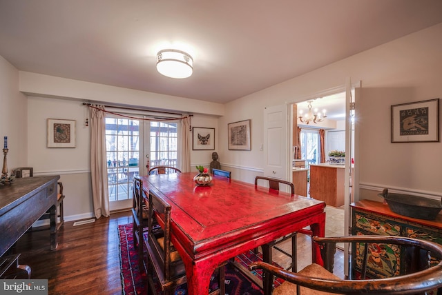 dining area with baseboards, french doors, dark wood-style flooring, and a chandelier