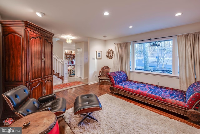 living area featuring recessed lighting, baseboards, wood finished floors, and stairs