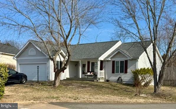 single story home featuring covered porch and a garage