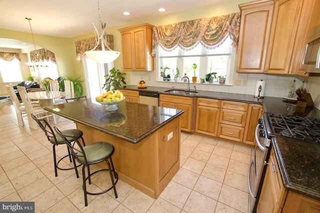 kitchen featuring a sink, tasteful backsplash, stainless steel range with gas cooktop, and white dishwasher