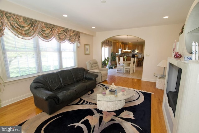 living room with recessed lighting, arched walkways, and wood finished floors