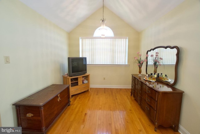 interior space featuring light wood-style flooring, baseboards, and vaulted ceiling