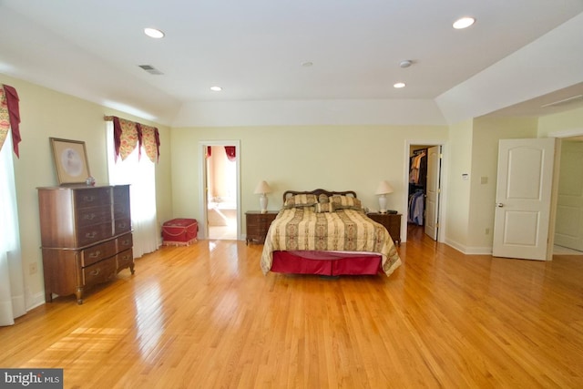 bedroom with recessed lighting, visible vents, a spacious closet, and light wood finished floors